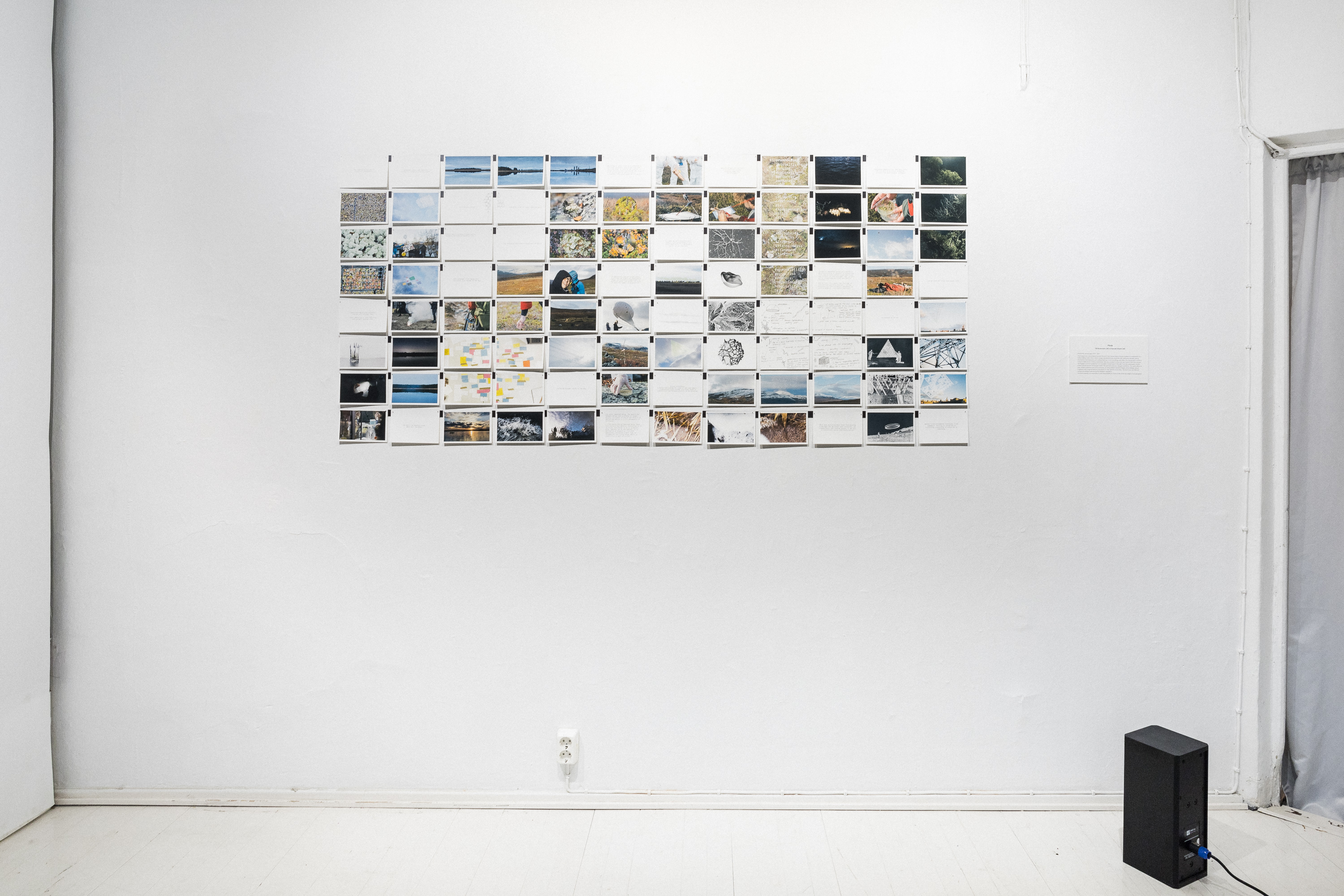 installation view with post card grid and speaker